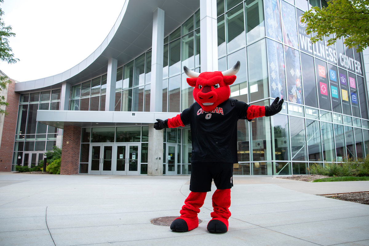 Durango poses in front of the Health and Kinesiology (H&K) building entrance.