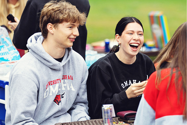 two friends are sitting outside at a picnic table