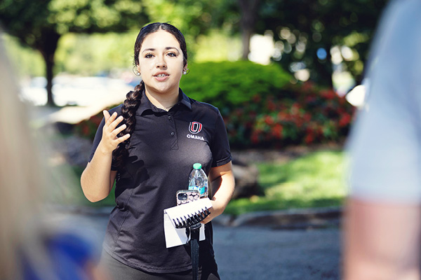 A transfer ambassador speaks with a student outdoors.