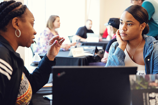 A student meets with a financial aid counselor in an office.