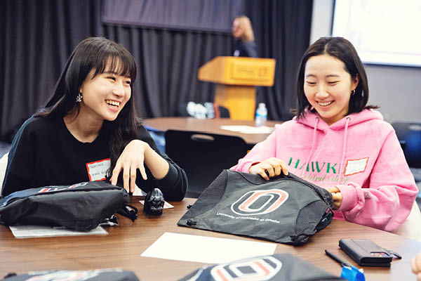 International students smile while talking during an orientation event.