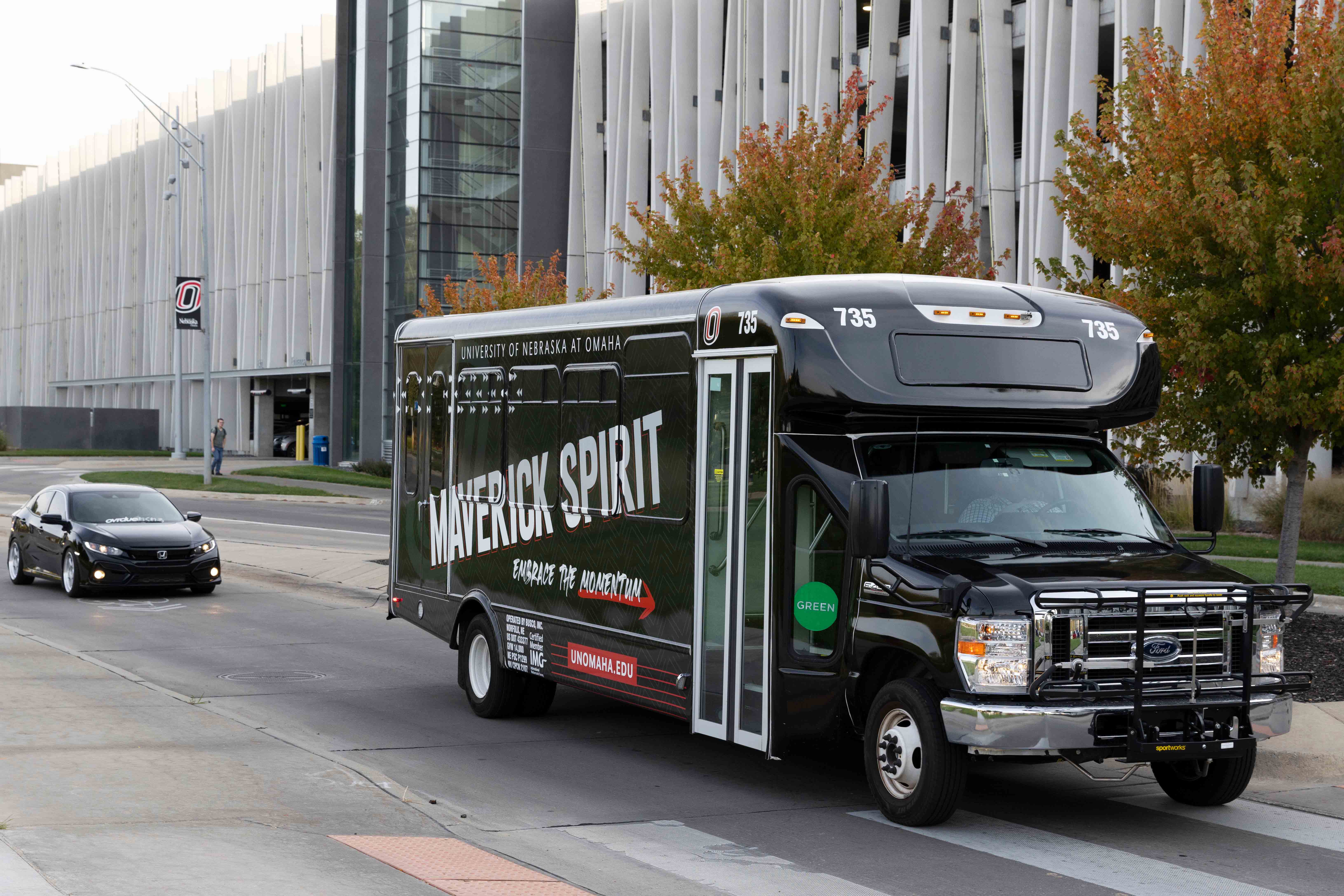 Photo of UNO shuttle bus with UNO graphics on it.