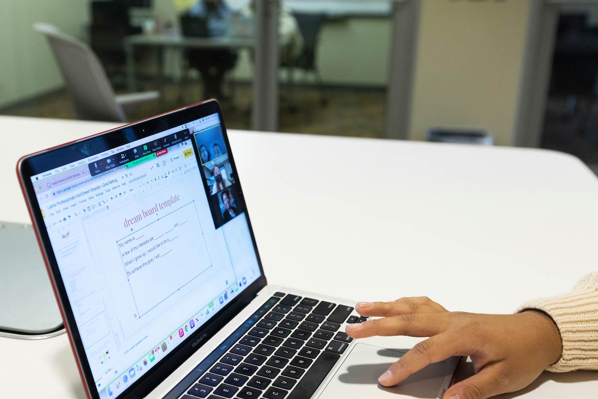 A computer with a Google Slides document reads dream board template with questions underneath it.