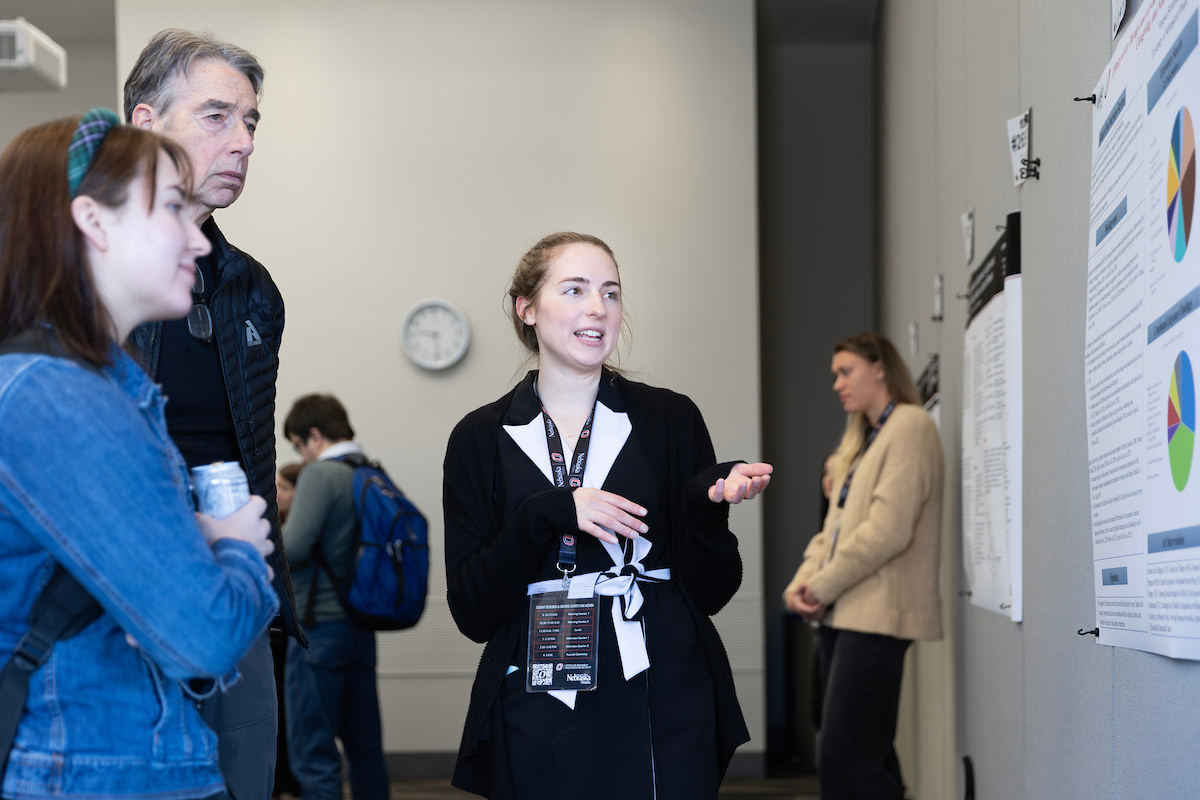 A student shares their poster presentation at the Research and Creative Activity Fair (RCAF) inside of UNO's Barbara Weitz Community Engagement Center.