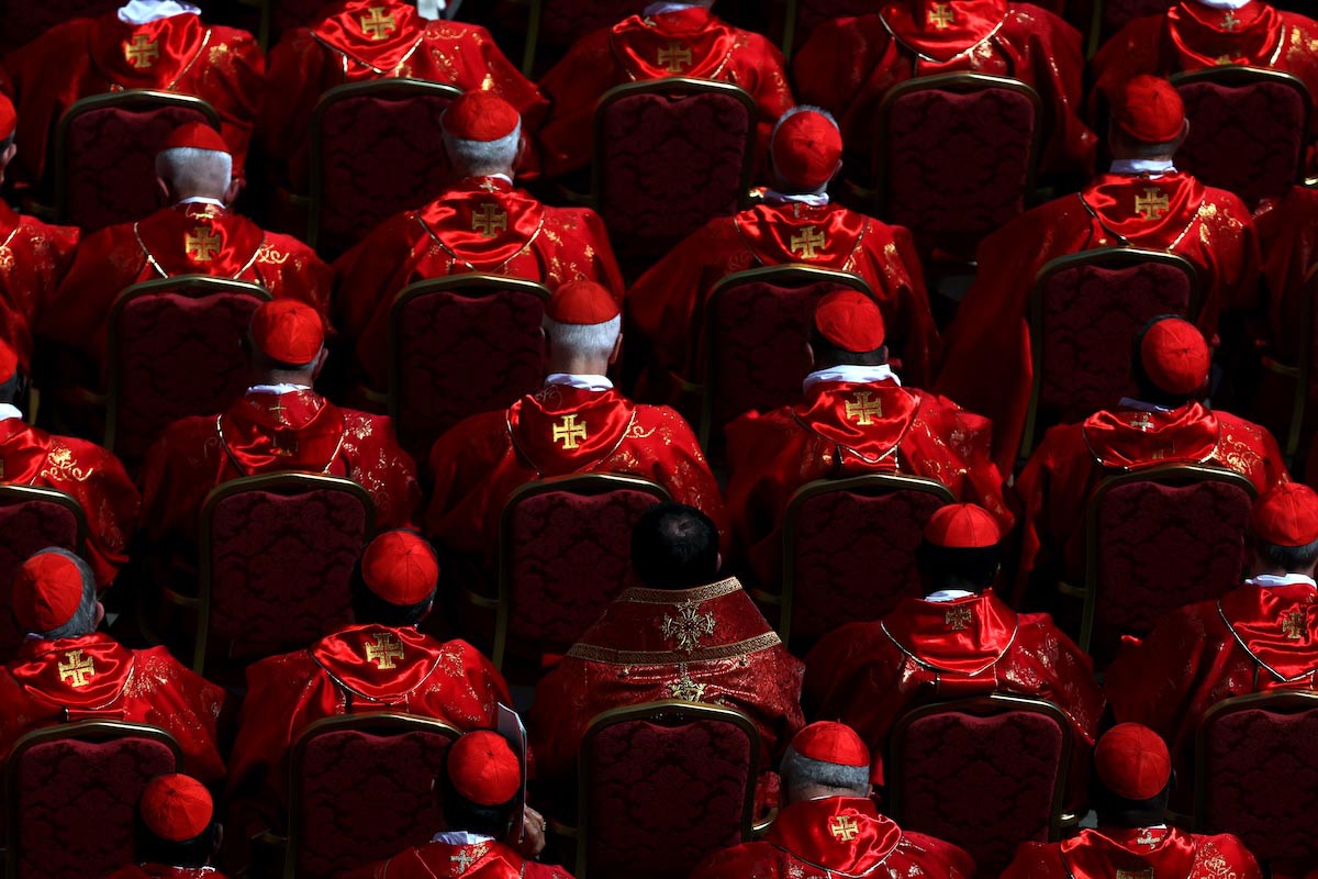 The purple red of the cardinals sitting in the churchyard to participate in the funeral of Pope Francis stands out across the entire square.