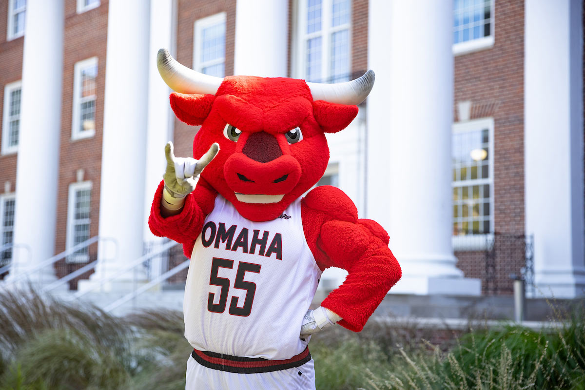 Durango throws up the horns in front of UNO's College of Arts and Sciences.