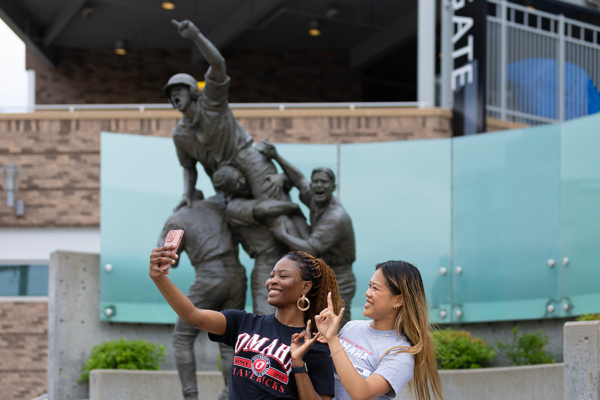 University of Nebraska at Omaha Social Media Ambassadors Miracle Olawuyi, left, and Lana Huetson have their pictures taken during the College World Series