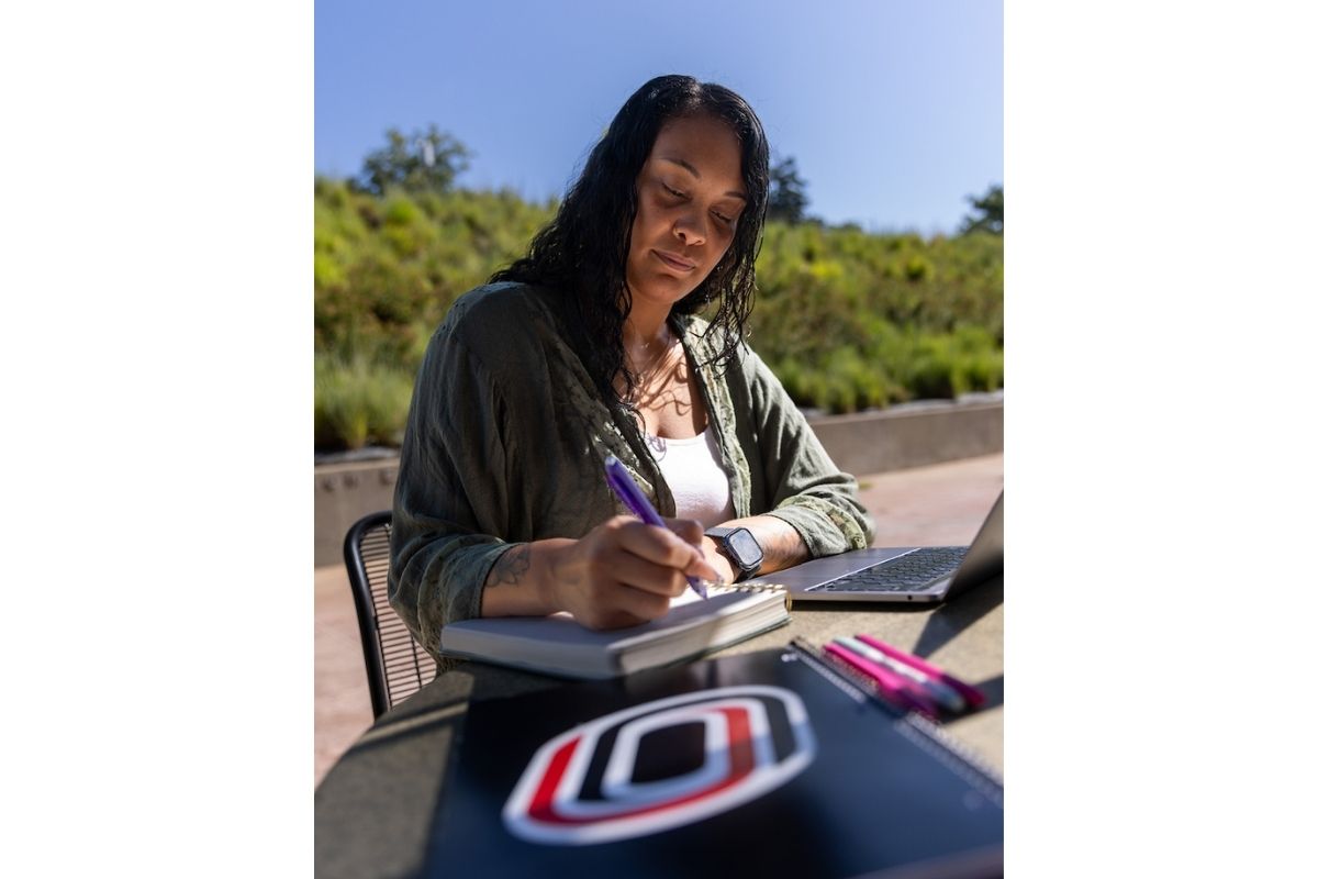 Kiera Kelly works on her online courses at a laptop.