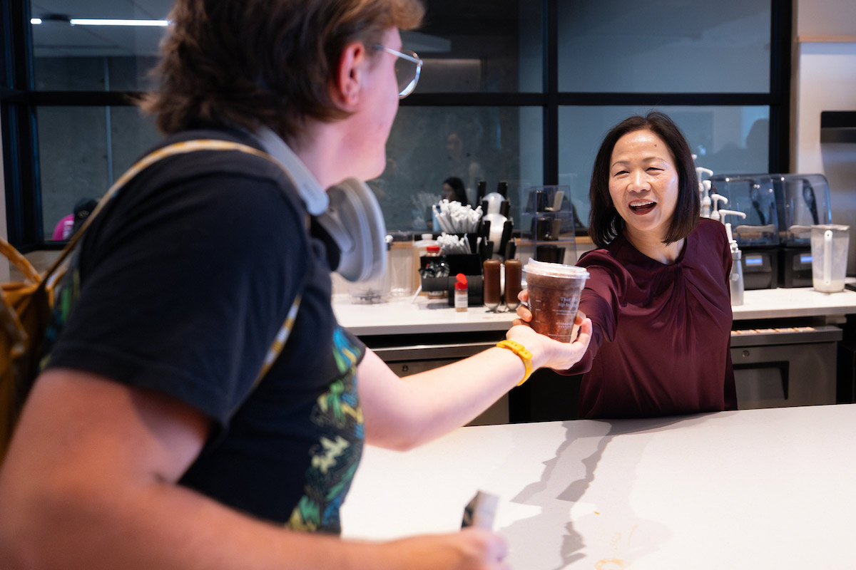 Chancellor Joanne Li smiles as she hands a student an iced coffee during Coffee Talk with Spirit and Tradition at UNO’s Criss Library Starbucks.