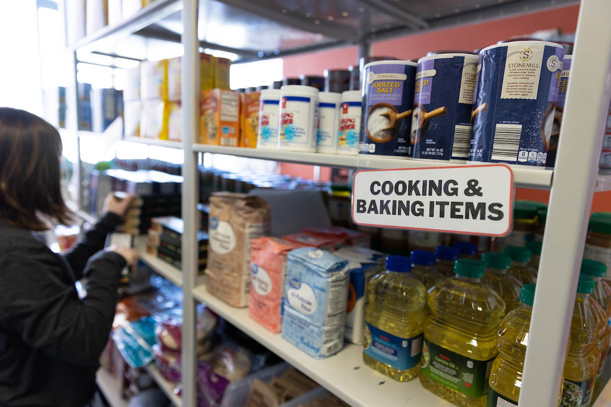 Shelves display bottles of oil and containers of flour, sugar, and salt in the pantry. 