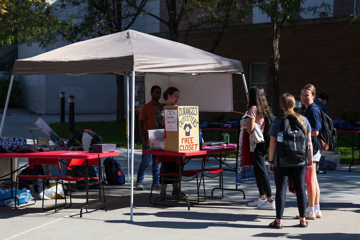Students gather under a canopy tent with a sign reading “Durango’s Outfitters Free Closet” during the pop-up clothing event.