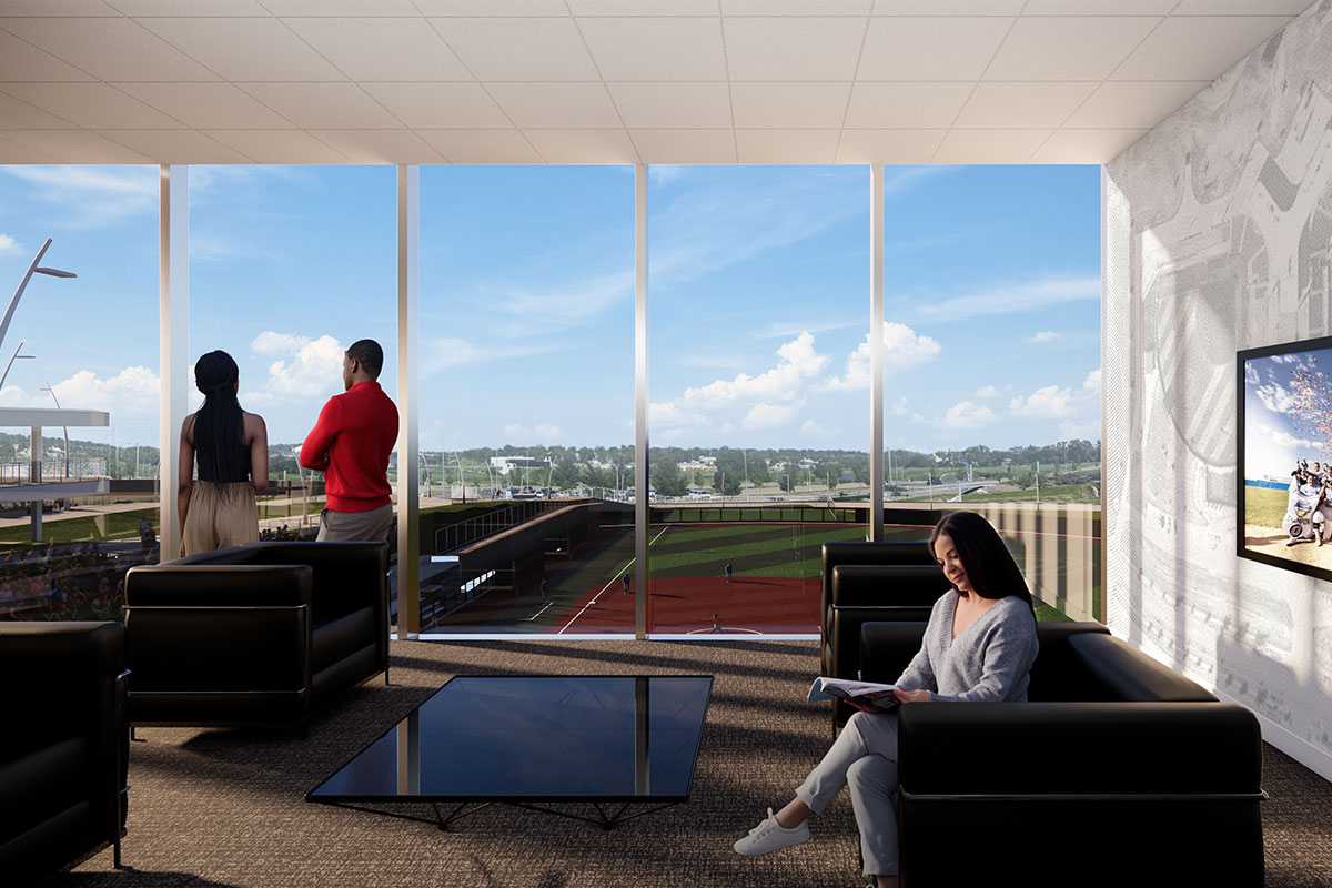People sit and stand inside a modern lounge with large windows overlooking an outdoor field.