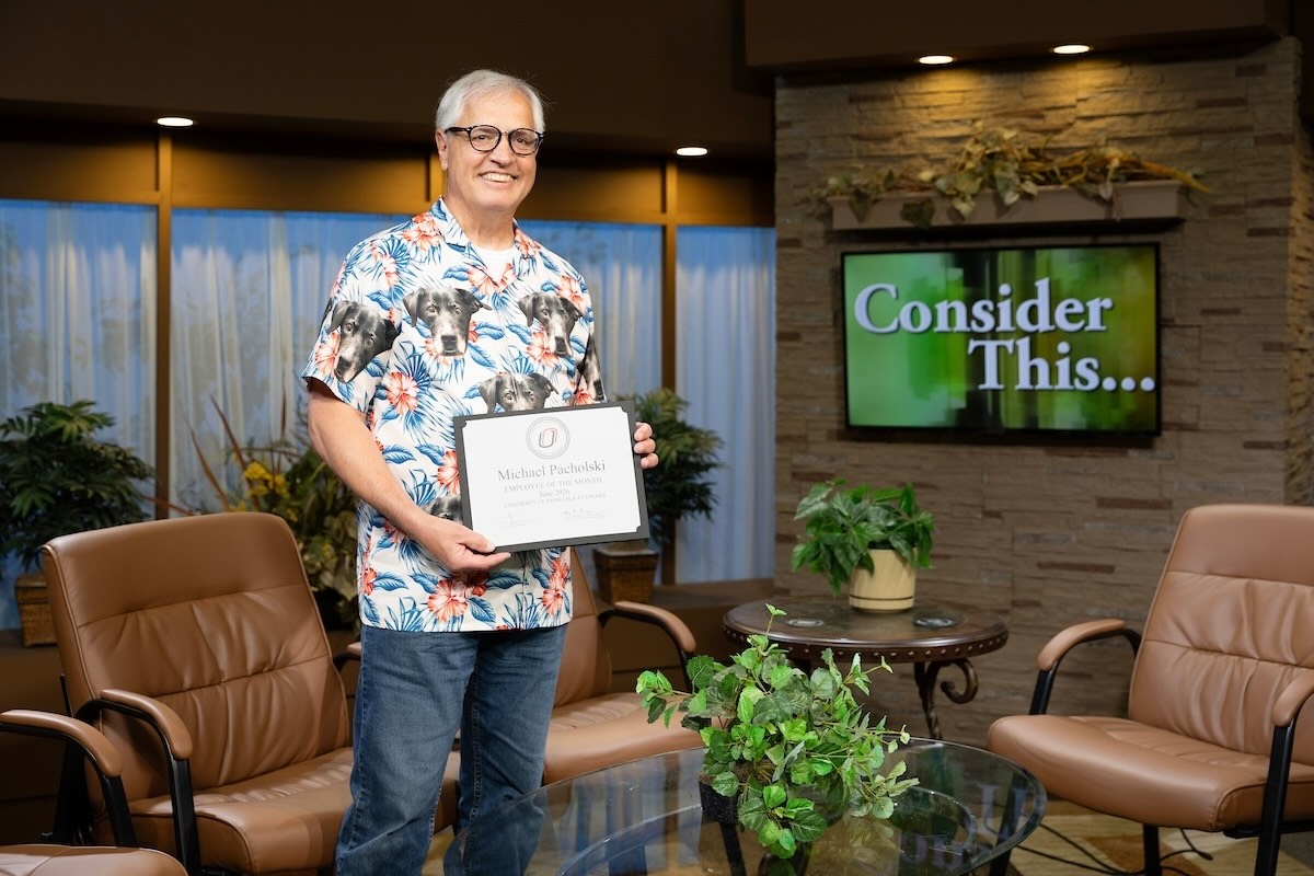 Michael Pacholski holds his certificate on the set of "Consider This."