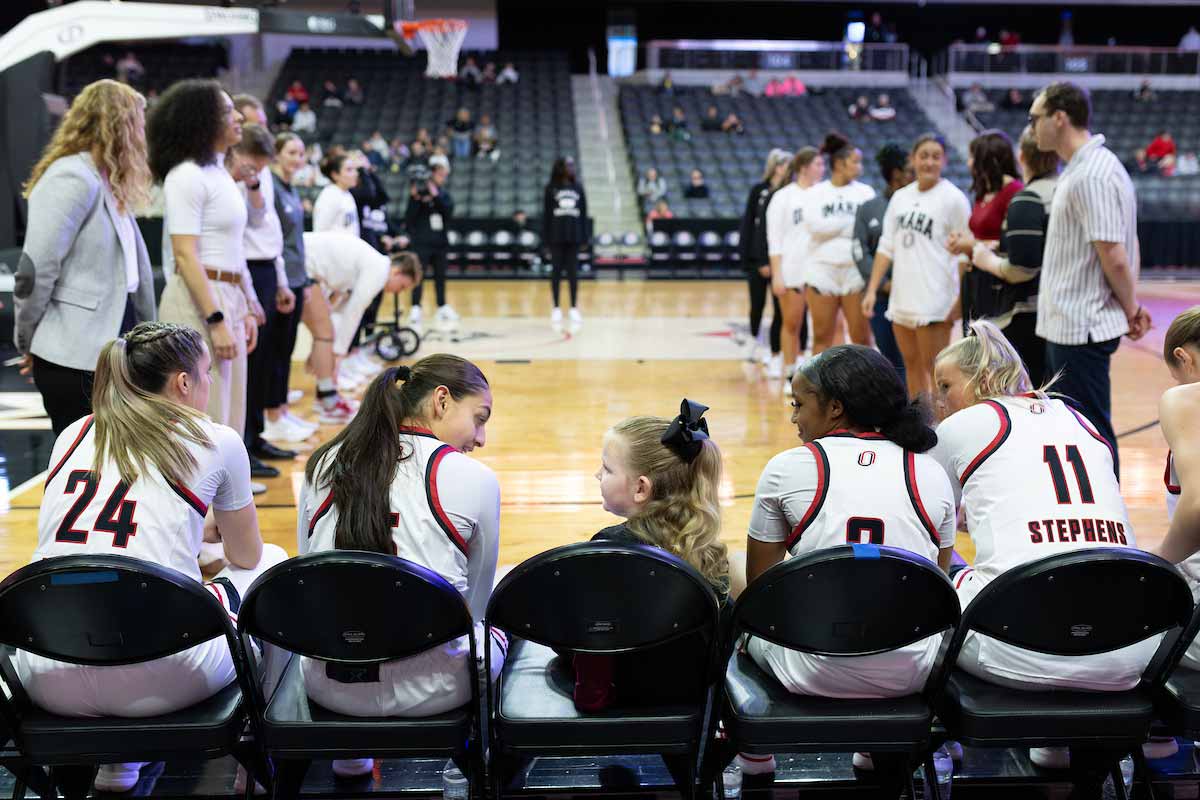 Sarai Estupiñan, center left, talks with a fan during introductions before a game.