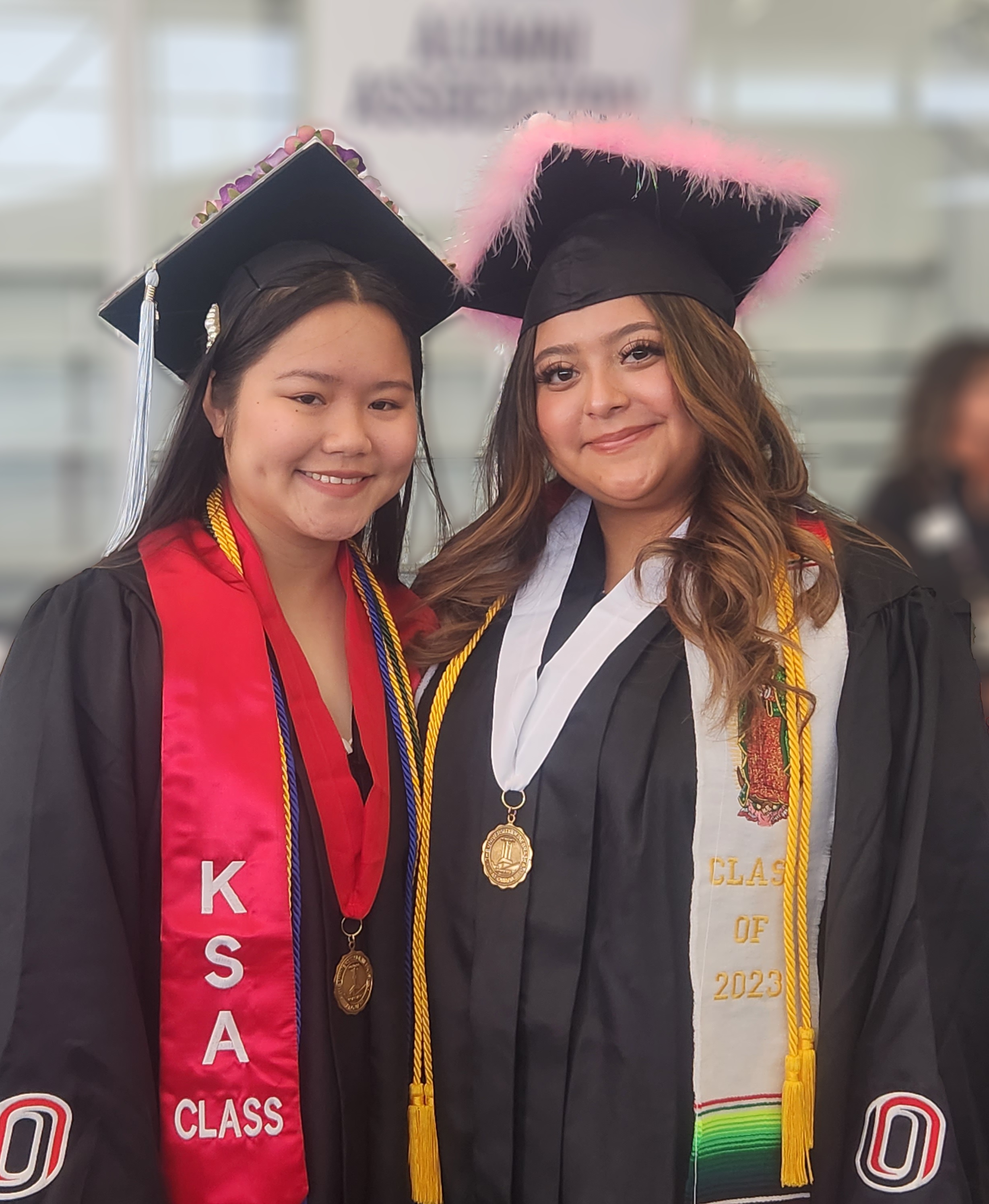 Two UNO graduates with their cap and gown.