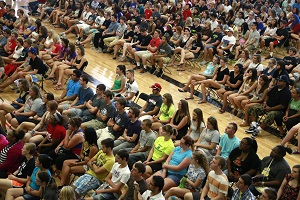 A crowd of students sitting in a gym.