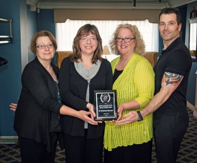 group of people standing together holding a plaque.