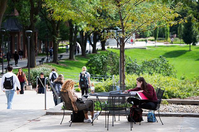 uno students sitting outside at a table.
