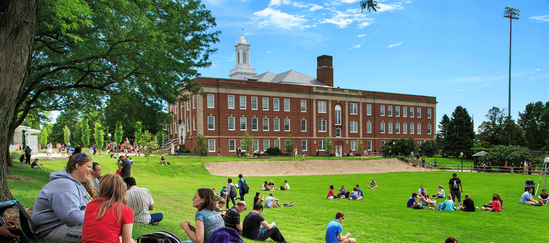 Students sitting in Pep Bowl on UNO's Dodge Campus on a sunny day.