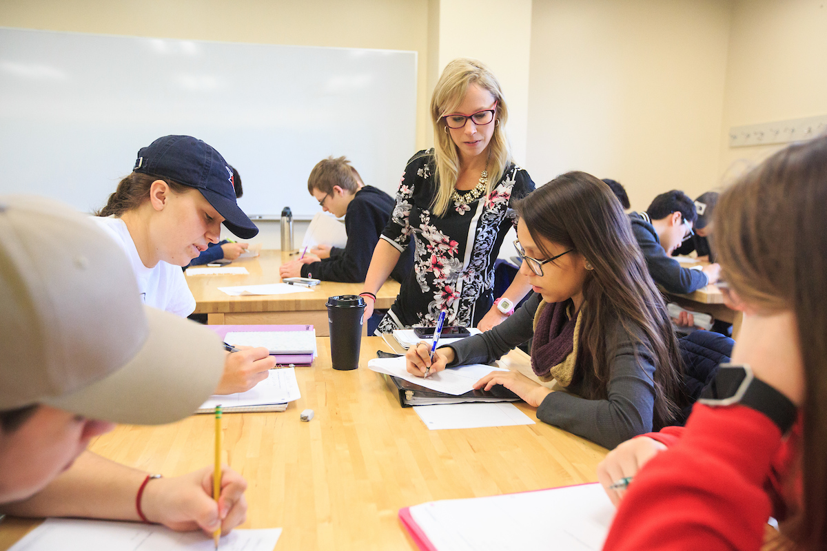 Professor helping students with coursework.