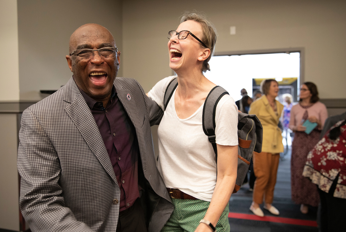 Two staff members smiling and hugging.