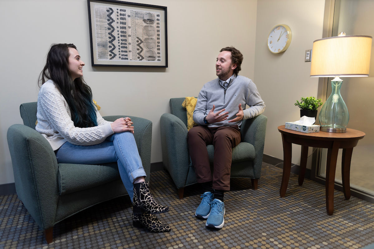 Two students sitting down together and talking.
